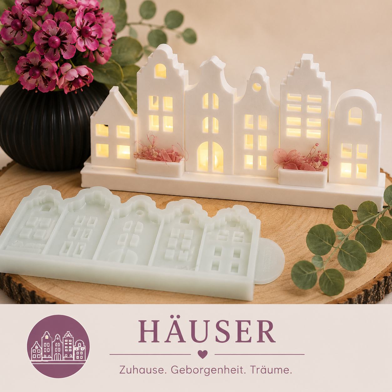 Kategoriebild „Häuser“ mit weißen Häuser-Motiven und passender Silikonform auf Holzscheibe, dekoriert mit rosa Blumen und Eukalyptus.
