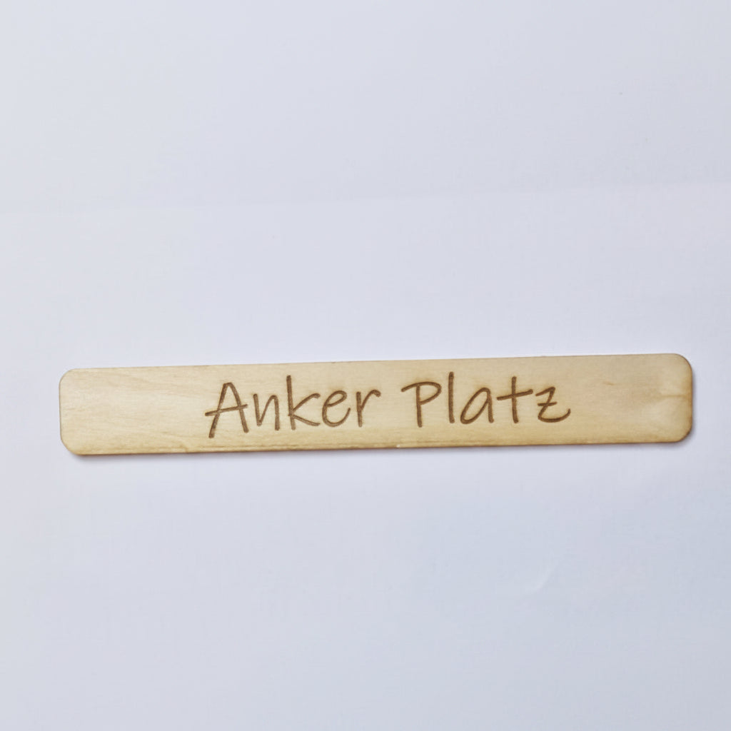 Detailansicht von gelaserten Holz Schriftzügen für Einstecker und Einschieber Halterungen