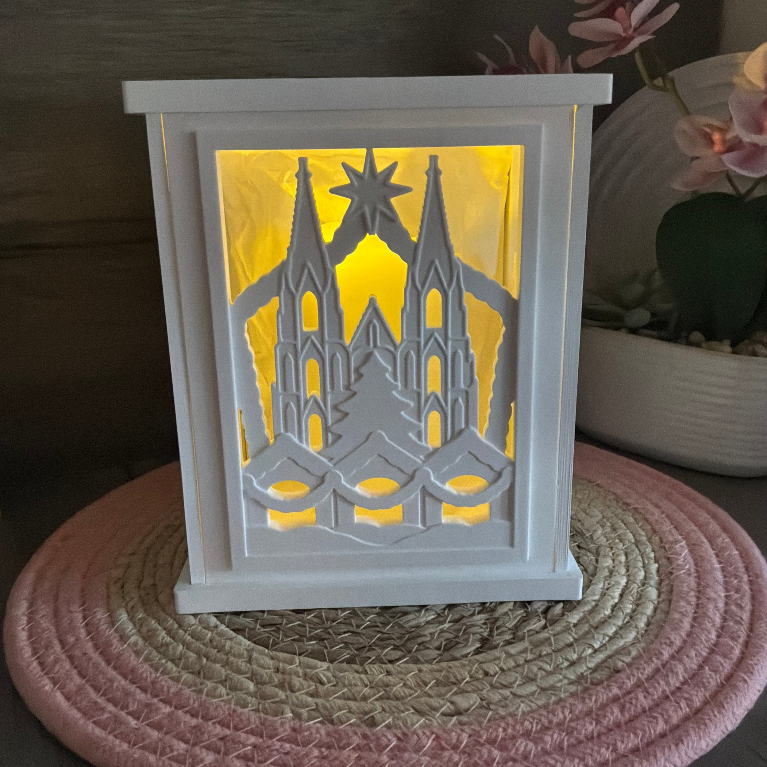 Beleuchtete Laterne mit Köln Dom, Weihnachtsbaum und Weihnachtsstern als stimmungsvolle Weihnachtsdekoration