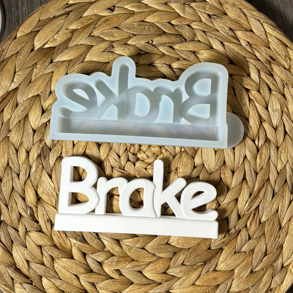 Silikonform für einen Brake-Schriftzug mit Standfläche und weißem Gießling