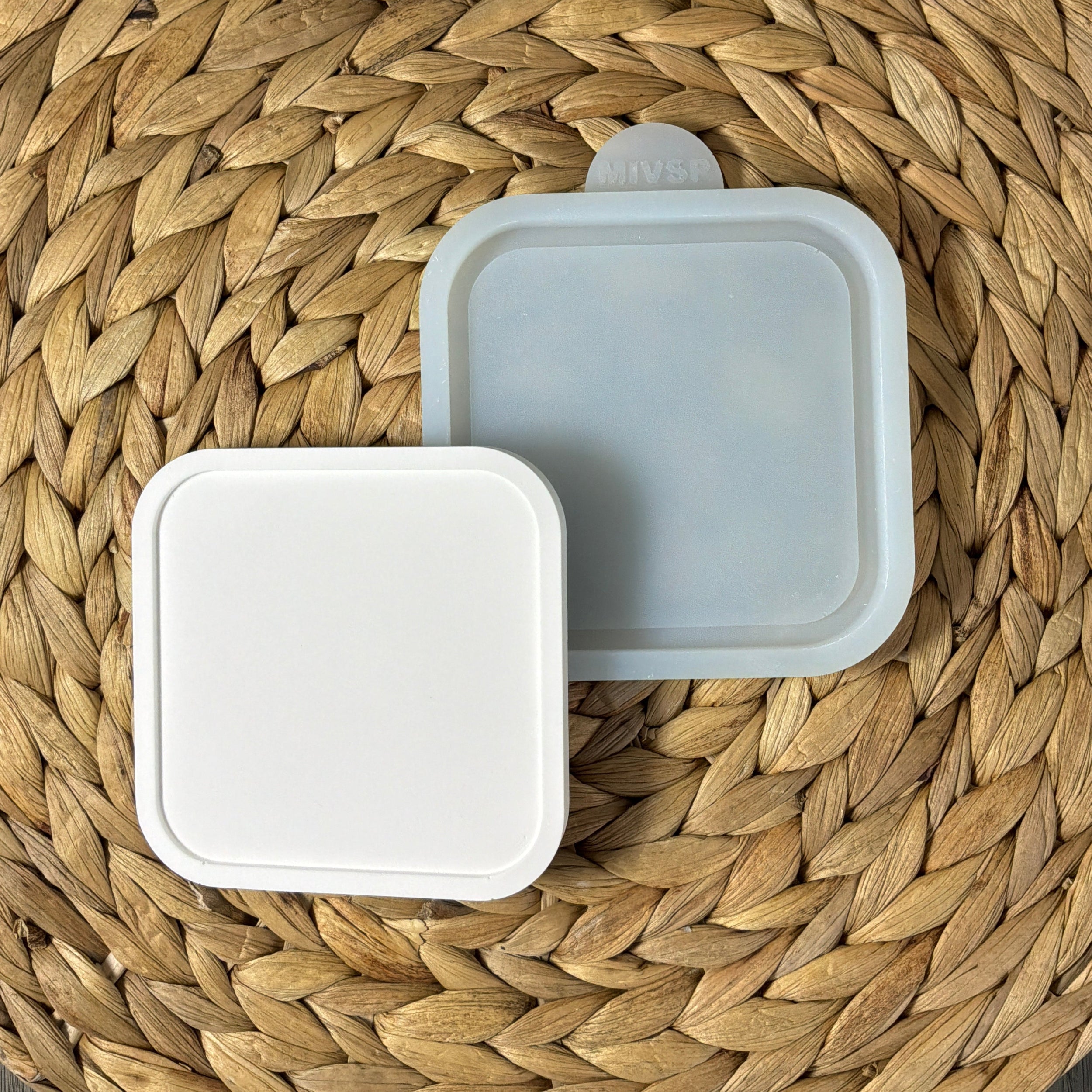 Silikonform für einen quadratischen Untersetzer 10 × 10 cm mit abgerundeten Ecken und gegossenem Beispiel aus weißem Gießmaterial